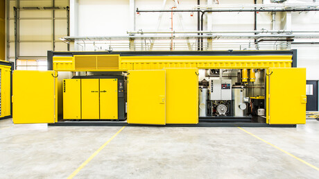 Atvērts saspiestā gaisa konteiners ar redzamiem Kaeser Kompressoren skrūves tipa kompresoriem